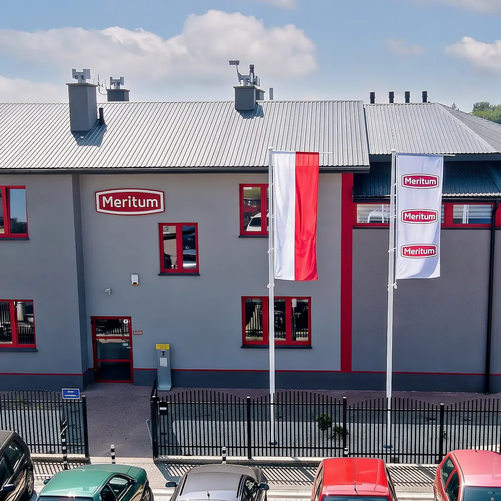 Siedziba firmy Meritum24 w Ziempniowie: budynek biurowy z logo Meritum i flagami przed wejściem